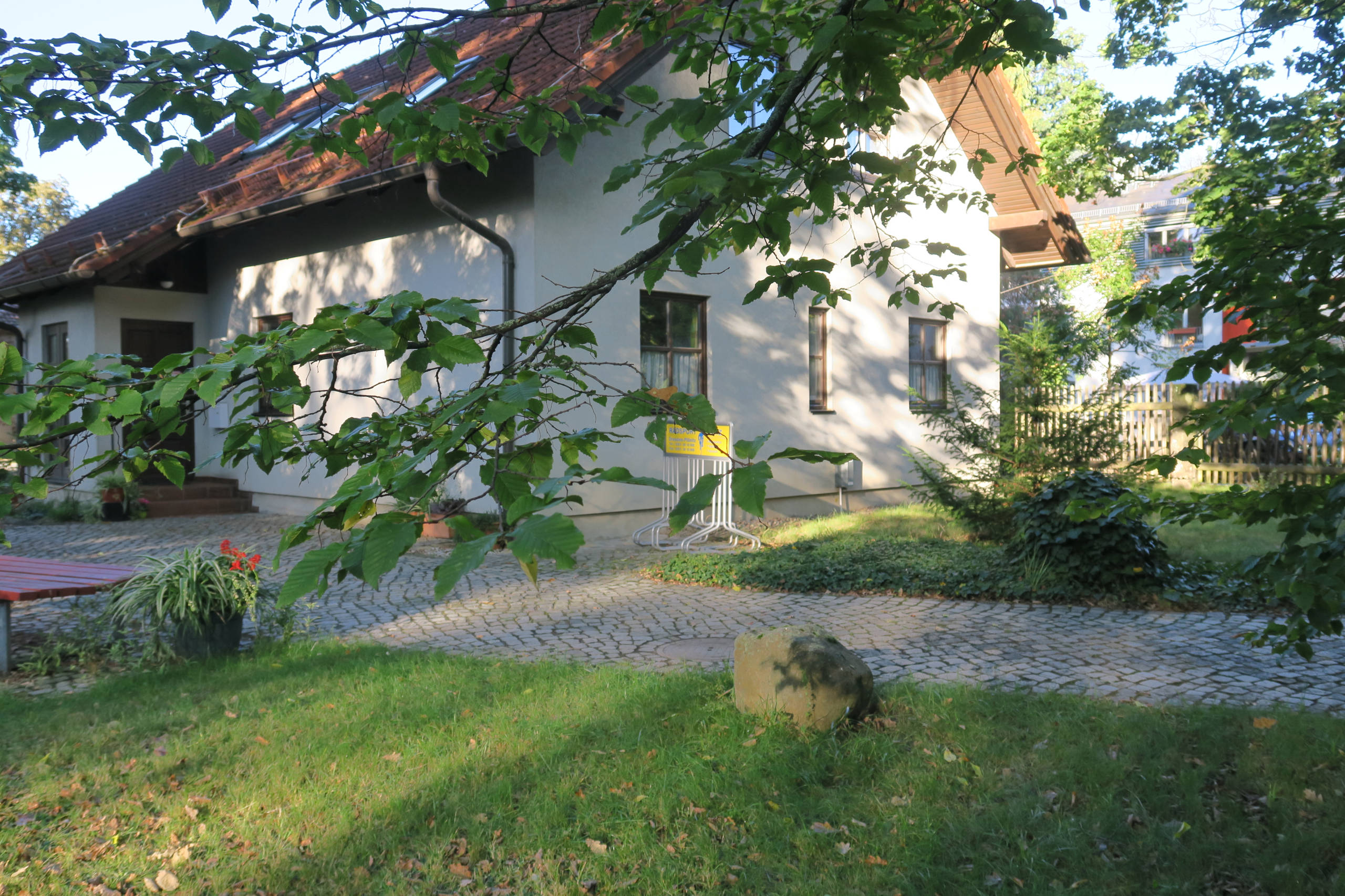 Gebäude der Zahnarztpraxis mit Teich und Garten